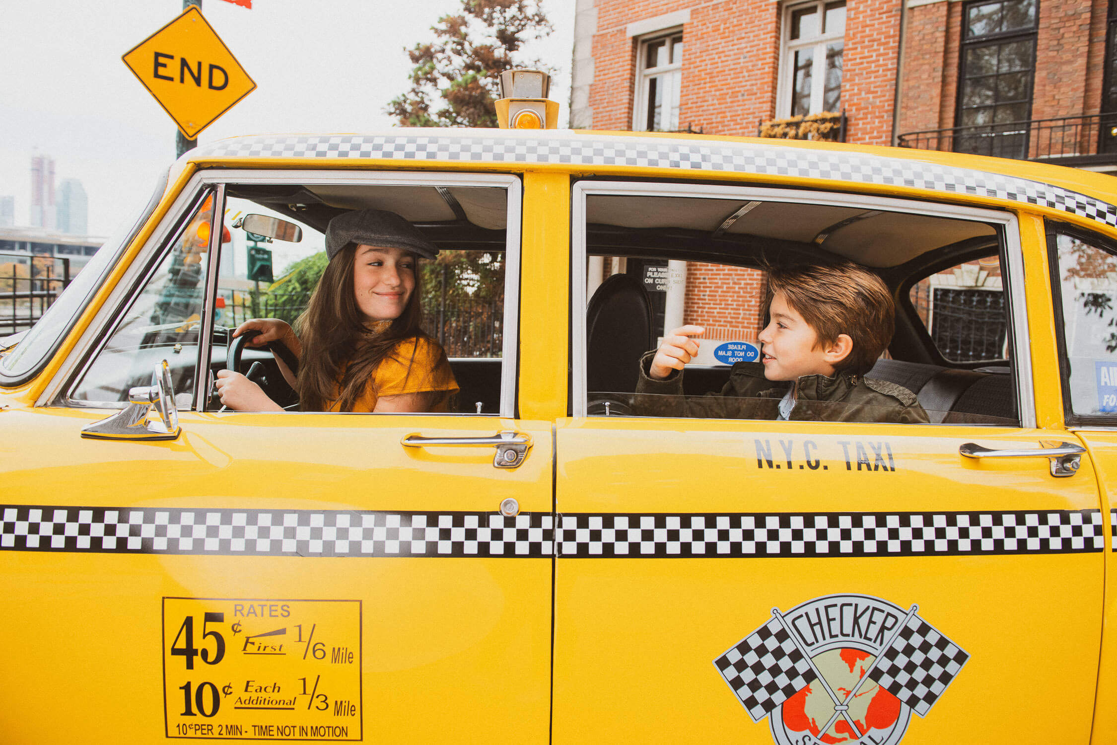 young boy and woman sitting in a classic yellow taxi, showcasing a New York city vibe