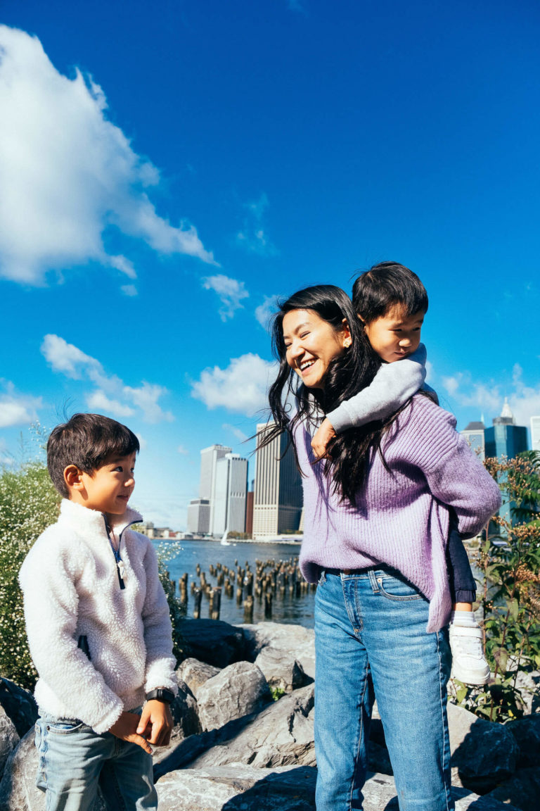 mom with her two boys in brooklyn brige park with manhattan skyline views