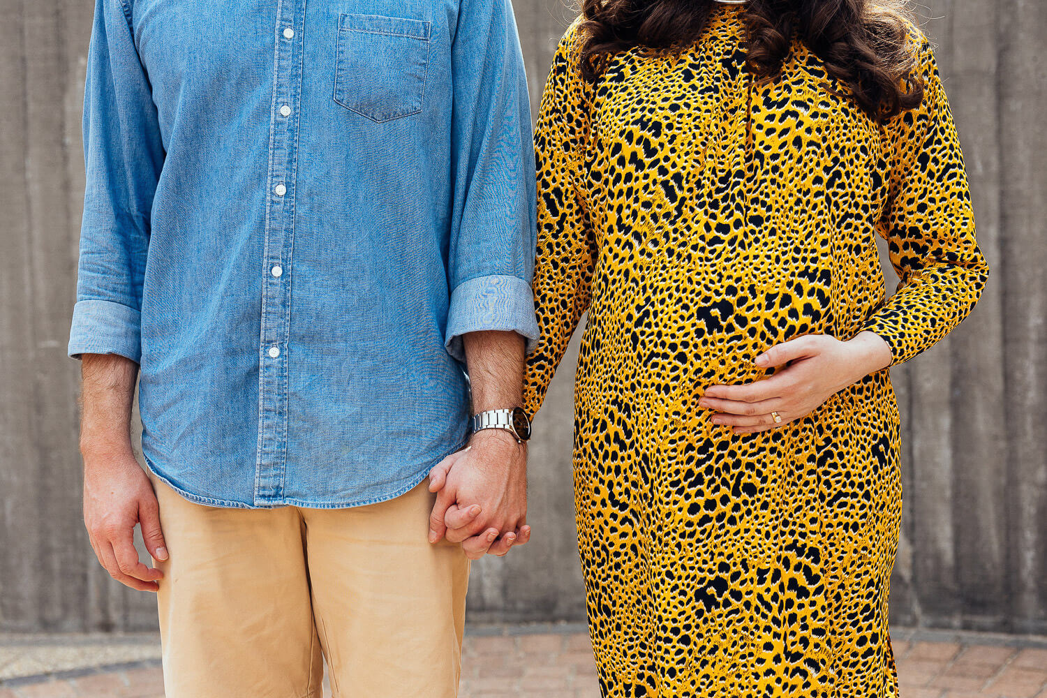 Pregnant woman in a vibrant chevron-patterned dress posing outdoors