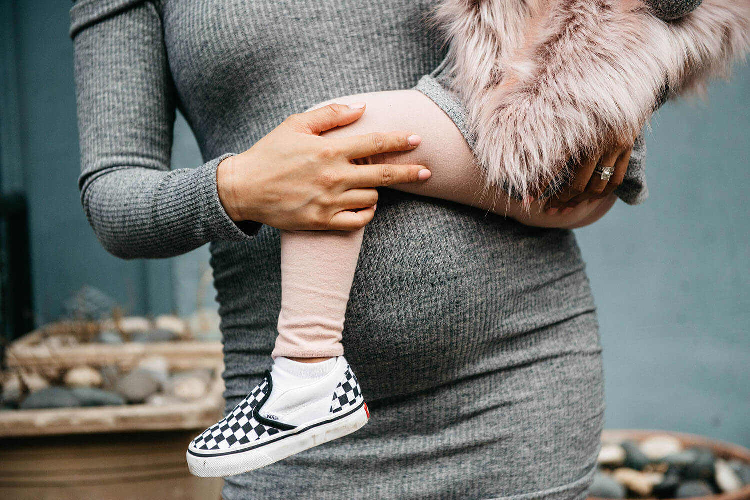 Pregnant woman standing in front of colorful graffiti wall with "Love" written in the background