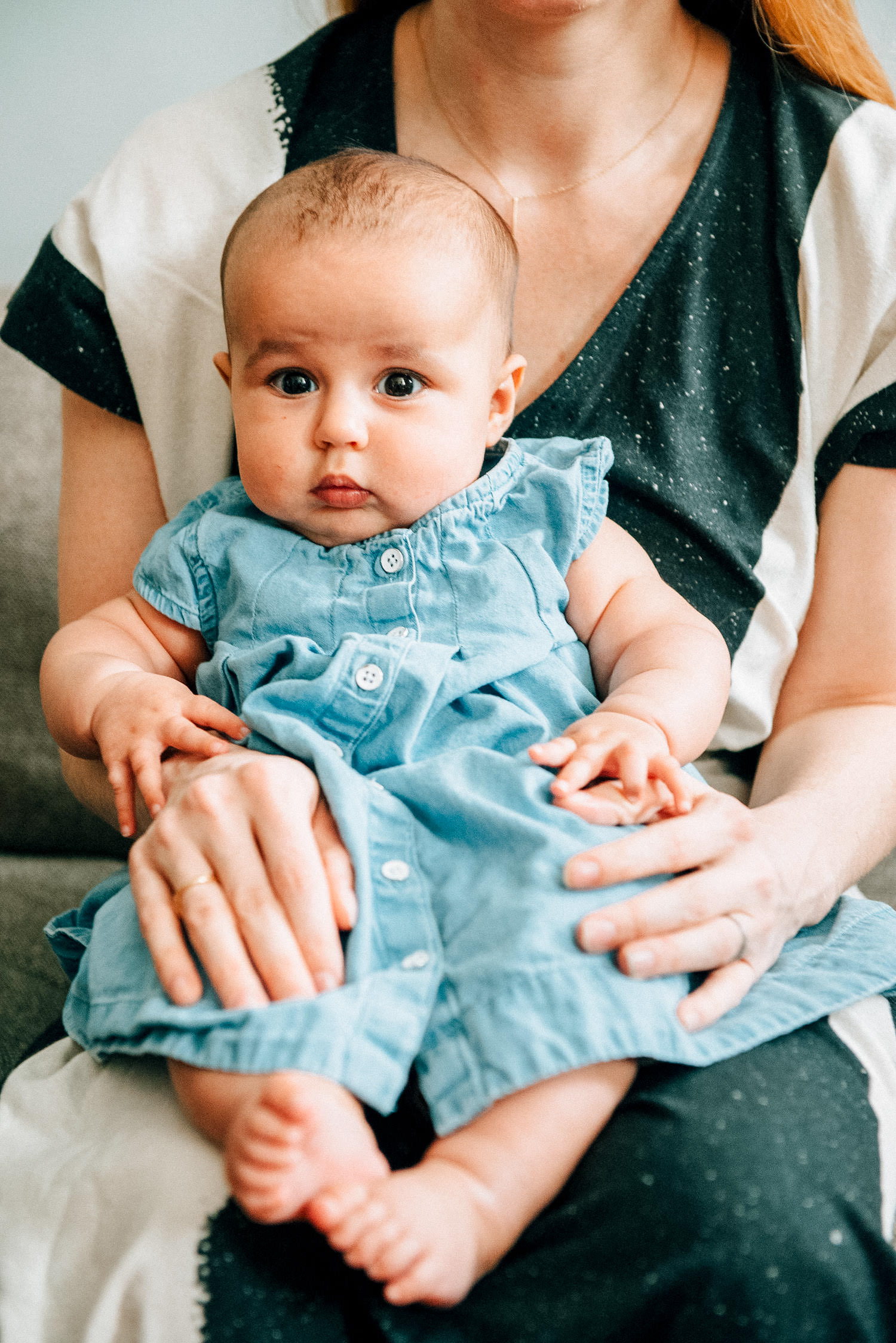 Fashion-forward new mother with baby in Brooklyn apartment showcasing small space newborn photos