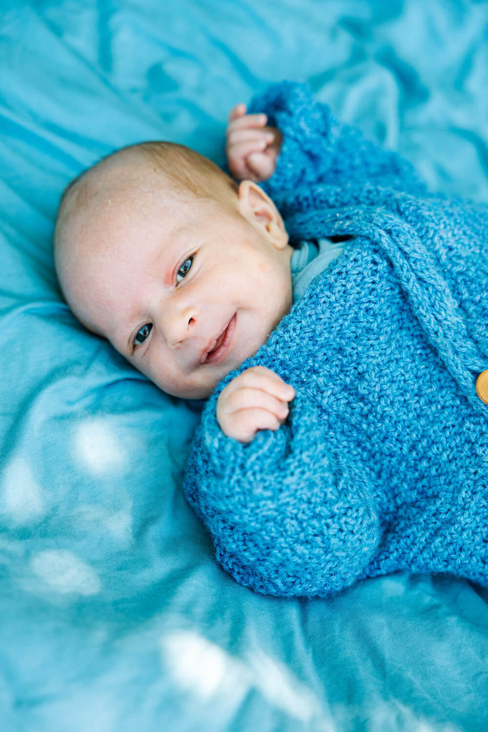 Beautiful newborn baby portrait with bright eyes looking at camera during NYC outdoor photography session