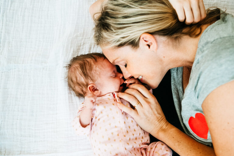 NYC newborn photographer captures intimate moment of mother and baby snuggling during weekday photography session